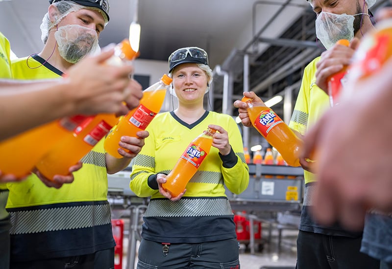 Mitarbeitende in der Produktion bei Coca-Cola in Fürstenfeldbruck mit neuem Flaschendesign.