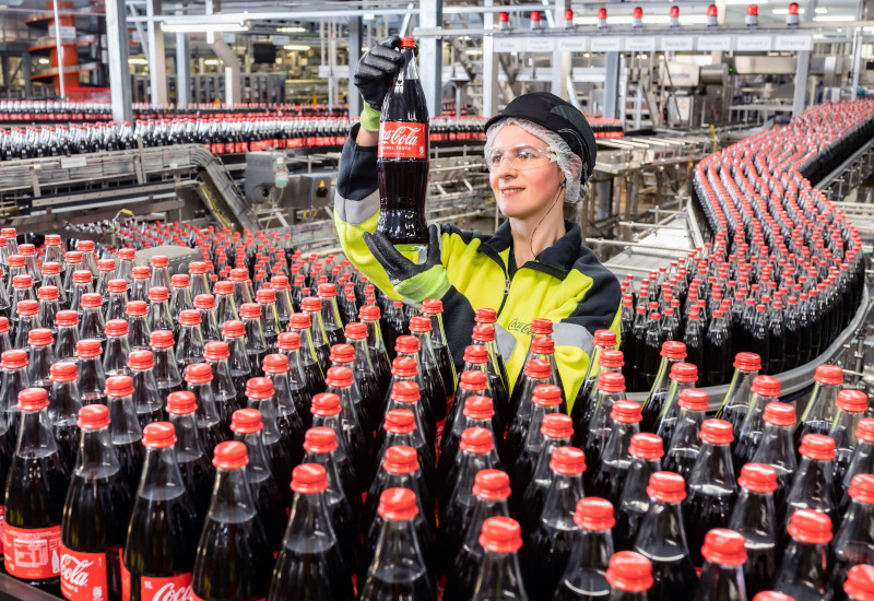 Coca-Cola Mitarbeiterin prüft 1-Liter-Glasflasche