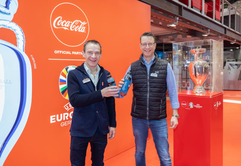 John Galvin, CEO CCEP DE und Daniel Osterloh mit dem Pokal der Fußball-Europameisterschaft