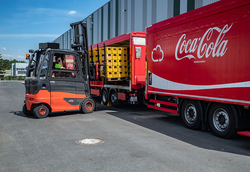 Staplerfahrer belädt Coca-Cola LKW mit Getränken