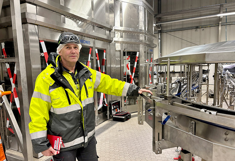 Ralf Bockelmann steht an dem Transportband der neuen Coca-Cola Produktionslinie