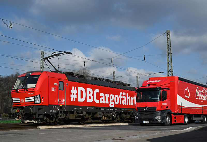 Darstellung des DB Cargo Schienenfahrzeugs und Coca-Cola LKWs