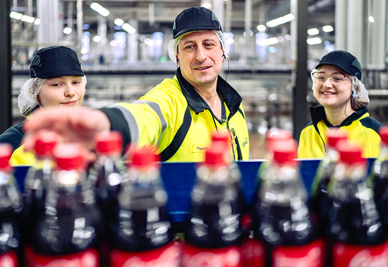 Vollzeit-Ausbilder Markus Markert während der Einarbeitung von zwei Auszubildenden in der Coca-Cola Produktion in Mönchengladbach