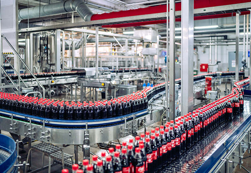 Produktionsbänder mit Coca-Cola Flaschen