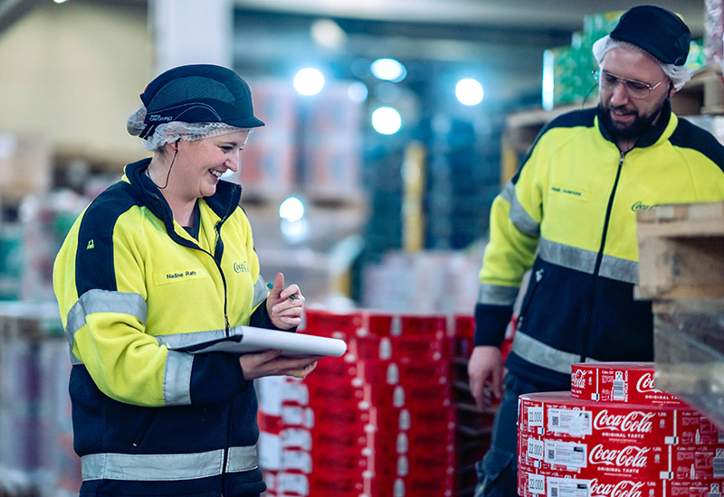 Zwei Mitarbeitende während der Arbeit in Coca-Cola Produktion in Mönchengladbach