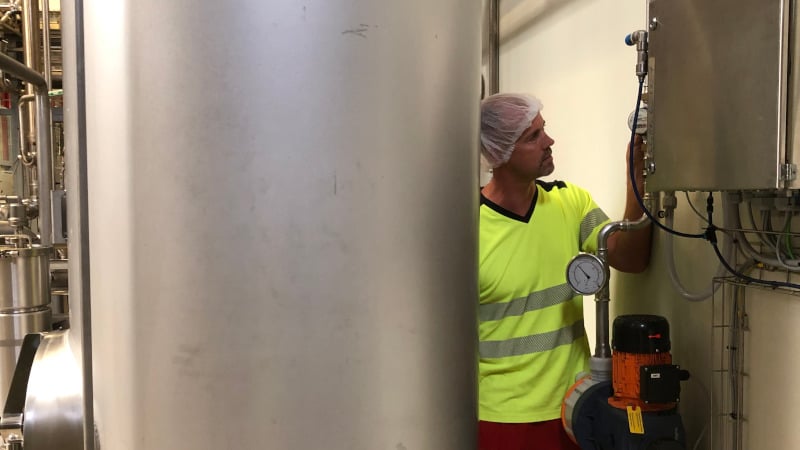 Ein Produktionsexperte von Coca-Cola an einem Gerät, das dabei hilft, Wasser in der Getränkeabfüllung zu sparen.  