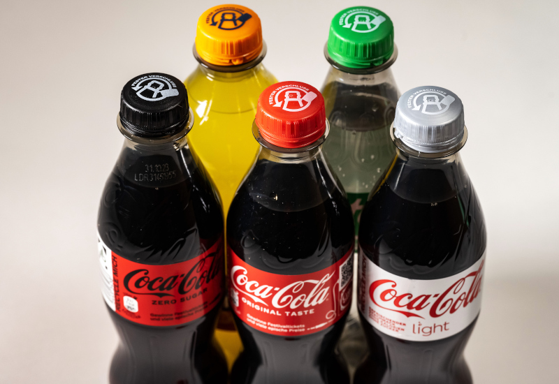 Darstellung von Coca-Cola Getränkeflaschen mit neuen Deckeln