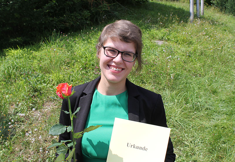 Dorothea mit einer Urkunde zum Staatspreis der Bayerischen Staatsregierung nach ihrem Ausbildungsabschluss