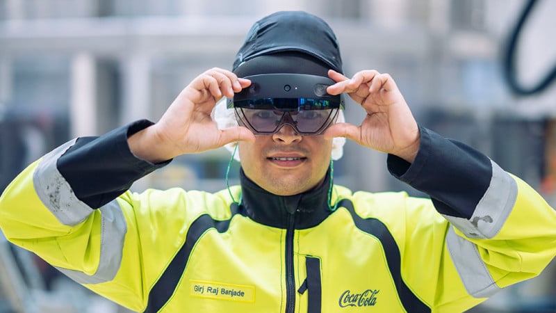 Auszubildender Giri Raj Banjade experimentiert am Coca-Cola Standort Mannheim mit einer Augmented Reality Brille. 