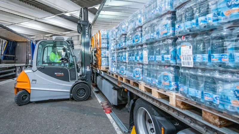 Arbeiten bei Coca-Cola: Gabelstaplerfahrer befüllt LKW mit VIO-Mineralwasser